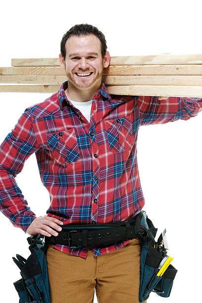 istock Smiling carpenter holding plank & looking at camera 505726913