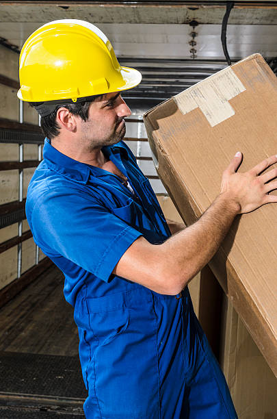 giovane dipendente in cappello rigido di portare un box - moving van relocation truck box foto e immagini stock