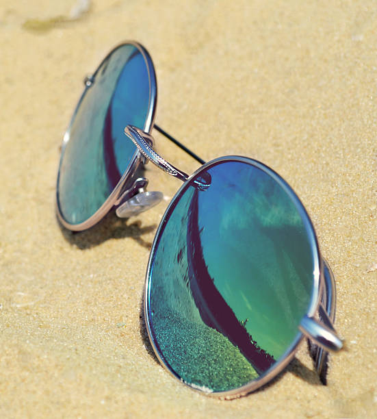 istock Mirrored sunglasses on sand with a reflection of the beach 505727197
