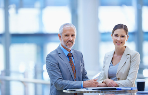 Portrait of a mature businessman standing with a younger female colleague