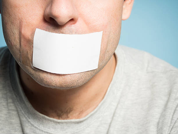 istock Caucasian man with duct tape on mouth, white . 505745206