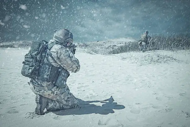 Two soldiers in actiorn through the snowstorm