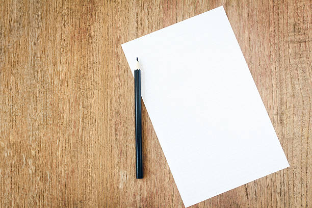 istock white paper with black pencil on wooden table 505747740