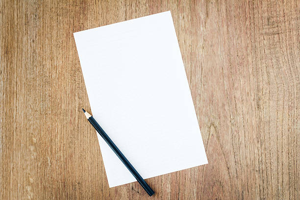 istock white paper with black pencil on wooden table 505748524