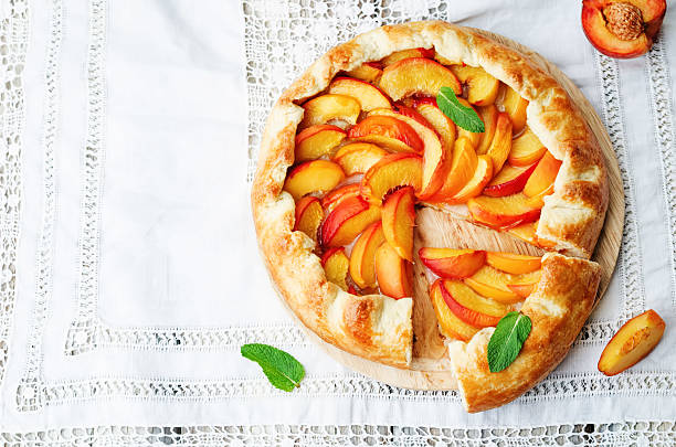 Galette with peaches Galette with peaches on a white background. the toning. selective focus crostata stock pictures, royalty-free photos & images