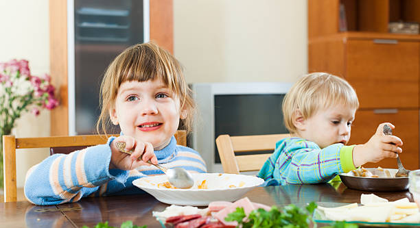 istock children eating food from plates 505769349