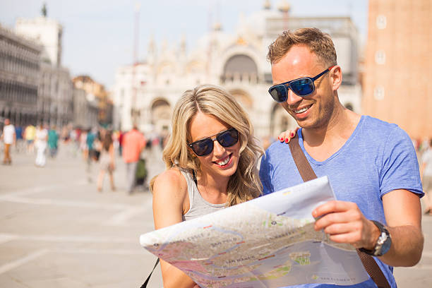 istock Tourists in Venice looking at city map 505769846