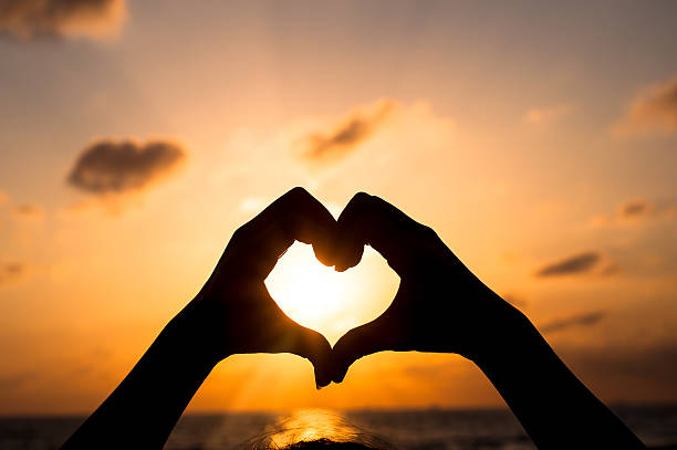 istock Love shape hand silhouette in sunset or dunrise period 505772400