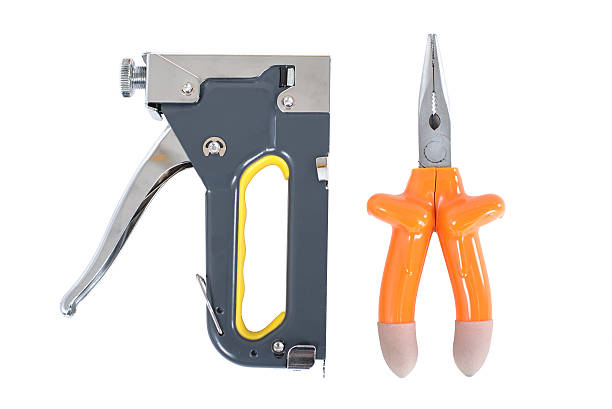 istock pliers and staple gun in hand on a white background 505773055