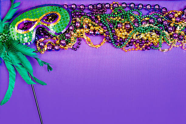 istock Mardi Gras background.  Purple, gold, green, mask, beads. 505775376