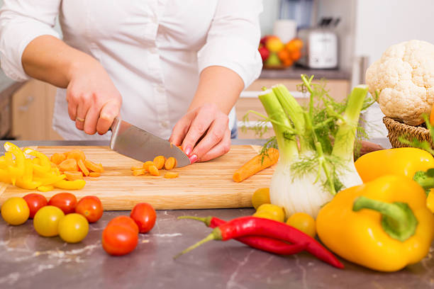 istock Woman in kitchen cutting vegetables 505777456