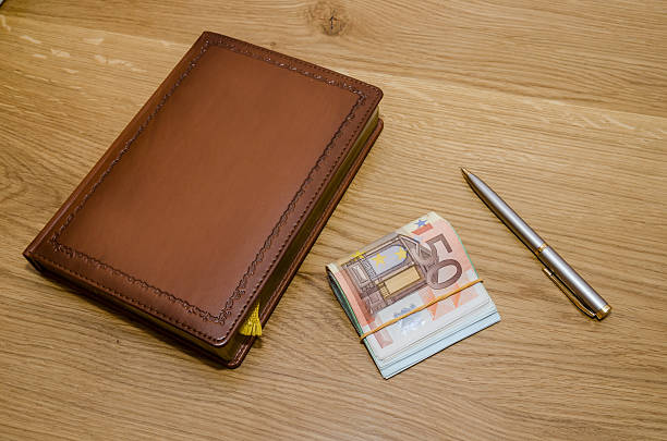 istock Closed luxury notepad with ball pen and some euro banknotes 505792214