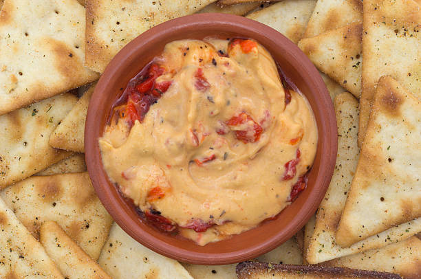 istock Red pepper hummus in a small bowl with crackers 505792658