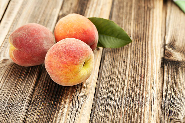 istock Ripe peaches fruit on a brown wooden background 505793082