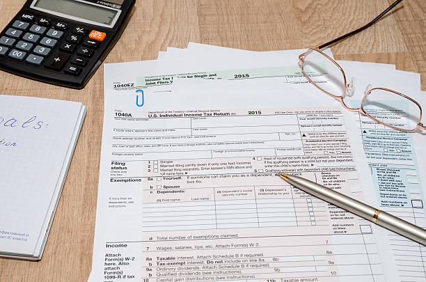 istock 1040, Tax Form with calculator and pen 505795650