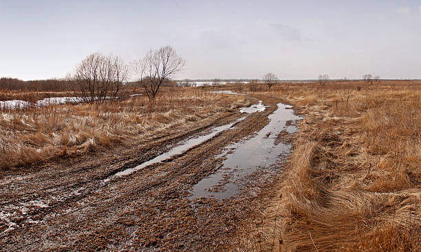 istock Spring road in puddles and mud 505795790