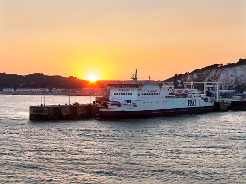 Dover, England - September 10, 2015: A P&O ferry moored at the port of Dover, with the white cliffs of Dover in the background