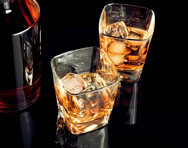 istock whiskey with ice in glass on black background 505797390