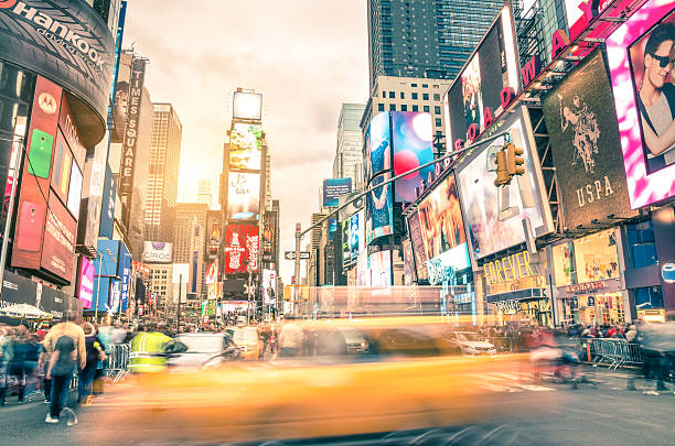 Blurred yellow taxi cab and rush hour in New York New York, United States - December 22, 2013: blurred yellow taxi cab and rush hour congestion at Times Square in Manhattan, one of the most visited tourist attractions in the world. Warm vintage filtered editing. broadway manhattan stock pictures, royalty-free photos & images