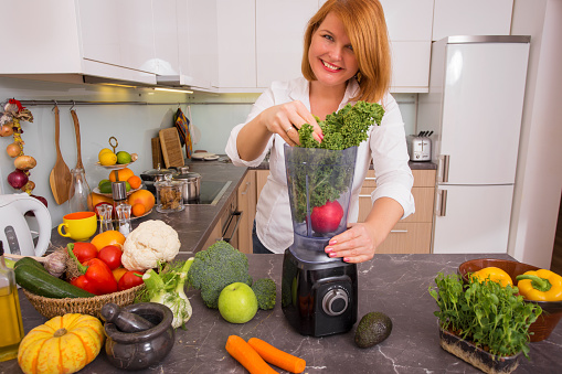 Woman blending vegetables