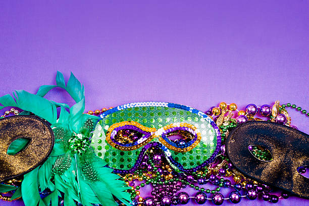 istock Mardi Gras background.  Purple, gold, green, masks, beads. 505801802