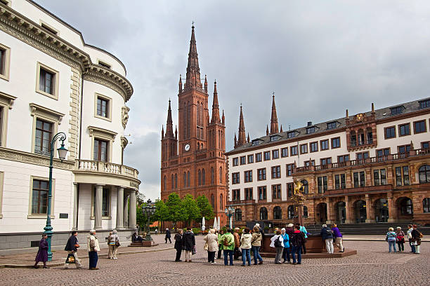 Wiesbaden, Germany - April 29, 2014: People walk on the Schlossplatz square in front of the new townhall and the  Marktkirche church in Wiesbaden, Germany on April 29, 2014