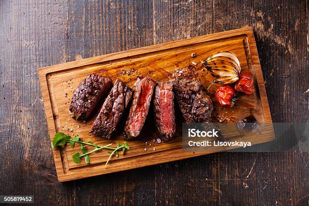 Sliced Steak Ribeye With Onions And Tomatoes Stock Photo - Download Image Now - Steak, Cutting Board, Grilled