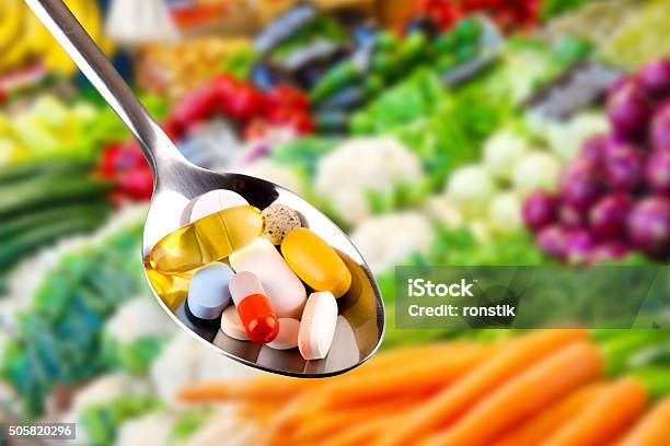 Cuchara Con Píldoras Y Suplementos Dietéticos En Fondo Vegetales Foto de stock y más banco de imágenes de Complemento vitamínico