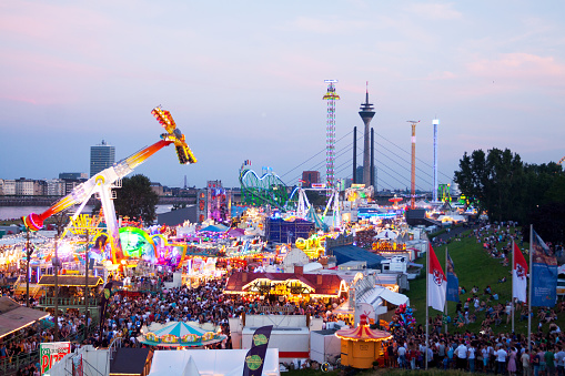 Düsseldorf, Germany - July 18, 2014: Aerial shot of crowd on summer fun fair in Düsseldorf Oberkassel. Sunset shot.