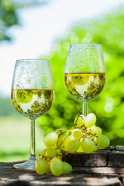 white wine with grapes on old wooden table