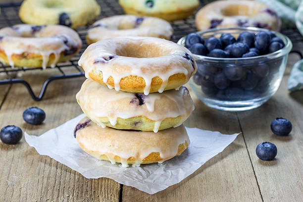 갓 구운 구은 도넛, 블루베리 및 레몬색 글레이즈 - bun bread cake dinner 뉴스 사진 이미지