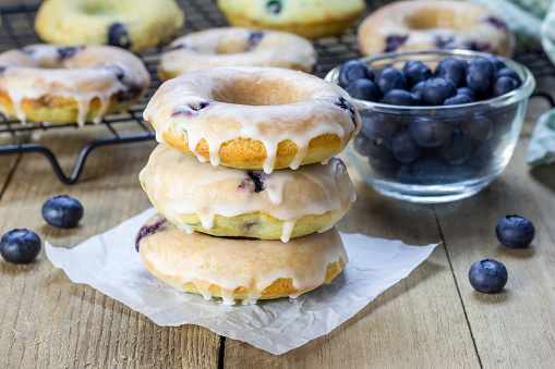 Freshly baked baked doughnuts with blueberries and lemon glaze, for breakfast