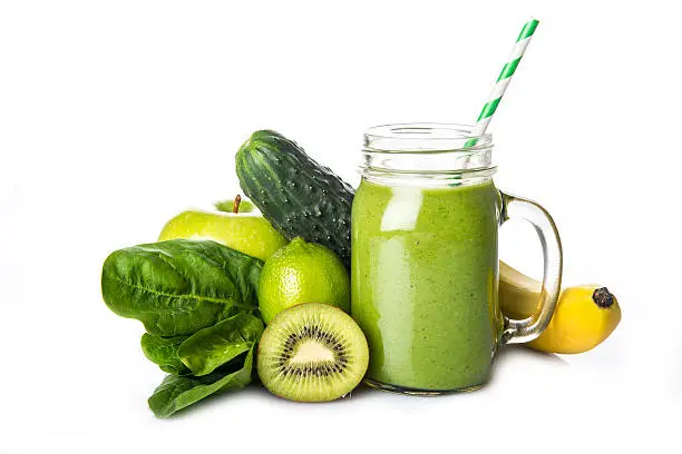 Fresh homemade green smoothie and ingredients isolated on a white background