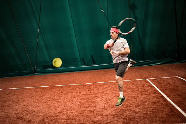 tennis-spieler-aktion: jumping vorhand - indoor tennis flash stock-fotos und bilder