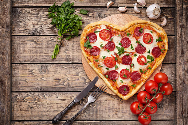 istock Valentines day heart shaped pizza with pepperoni, cherry tomatoes, mozzarella 505824990