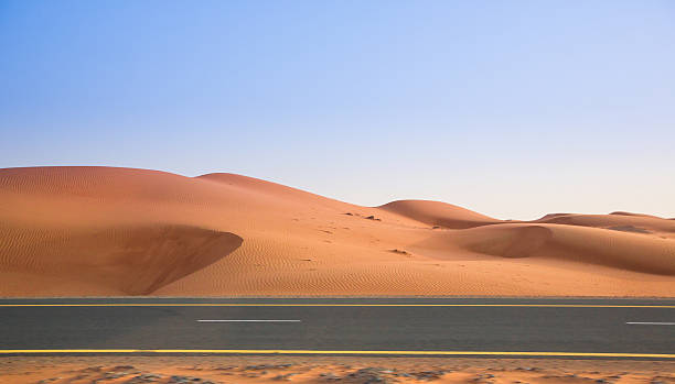 istock desert, sand dunes and the road in the evening 505825018