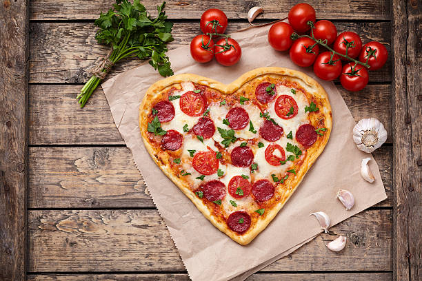 istock Pizza heart shaped with pepperoni, tomatoes, mozzarella, garlic and parsley 505825030