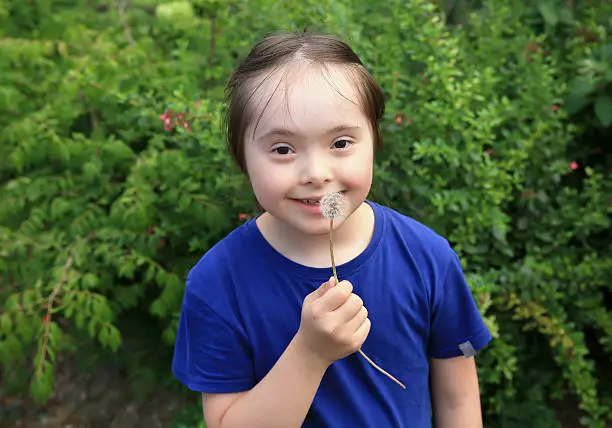 Photo of Little girl blowing dandelion