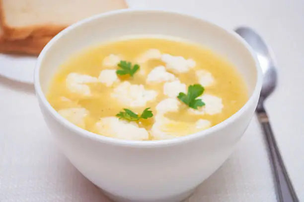 Cauliflower soup with cauliflower scraps served on a table