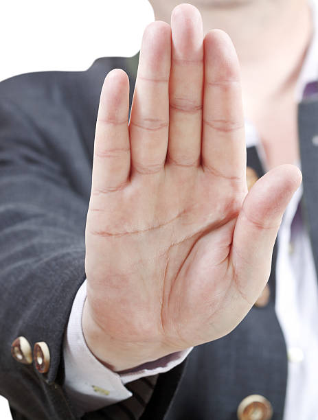 istock stop sign by one palm - businessman hand gesture 505839135
