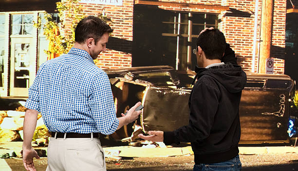 istock One man looking at mobile & the other upset 505839771