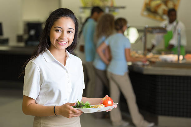 istock High school student holding healthy lunch in cafeteria 505839789