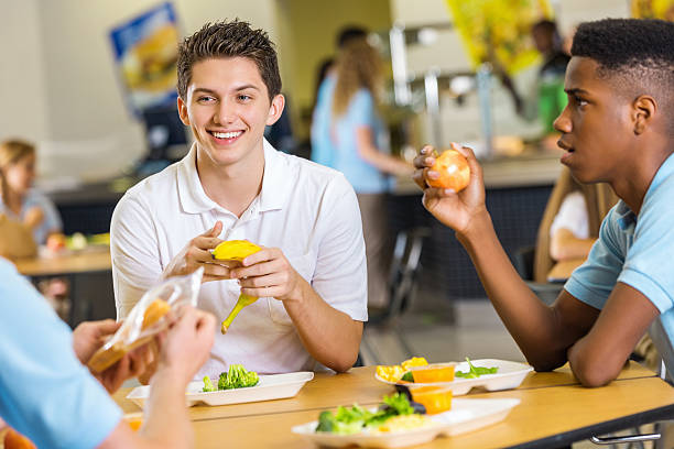 Friends having healthy lunch together in high school cafeteria Friends having healthy lunch together in high school cafeteria cafeteria sandwich food healthy eating stock pictures, royalty-free photos & images