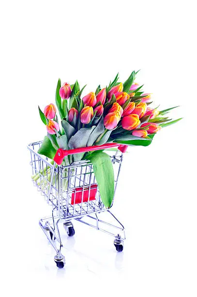 Bunch of orange-yellow tulips in shopping-cart from the supermarket