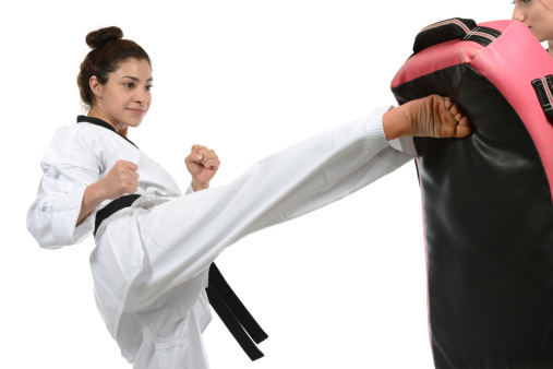 Martial artist training with a padded target.