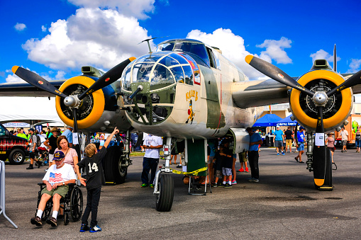 Fort Myers, FL, USA - November 7th, 2015: People of all ages standing looking at a ww2 B-25J Mitchell light bomber on display at the Fort Myers airport open day in Florida