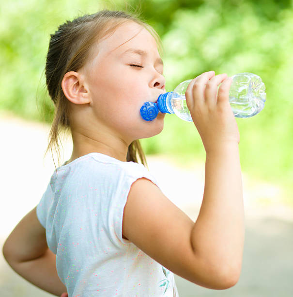 istock Cute girl drinks water from a plastic bottle 505841389