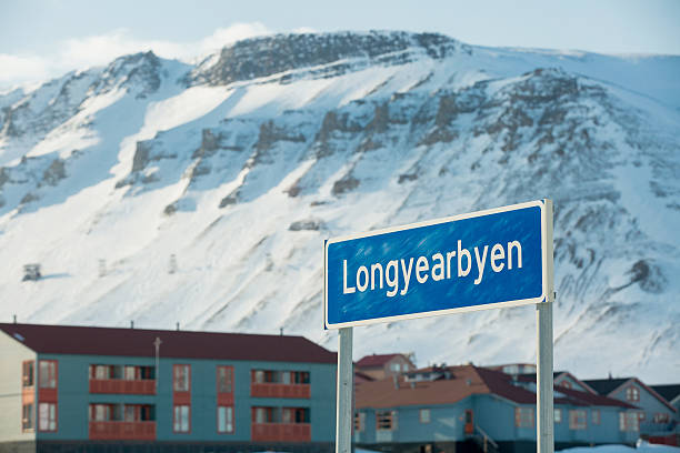Sign road and Beautiful white snowy landscape. Mountains and blue sky on the background. Sunny weather. Longyearbyen, Svalbard.