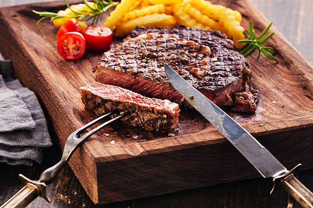 fatias de bife de costela com batata frita - rib eye steak beef cutting board meat - fotografias e filmes do acervo