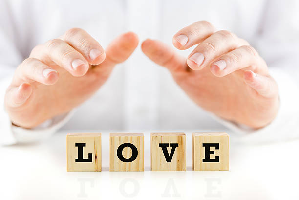 istock Man holding protective hands above the word Love 505844703
